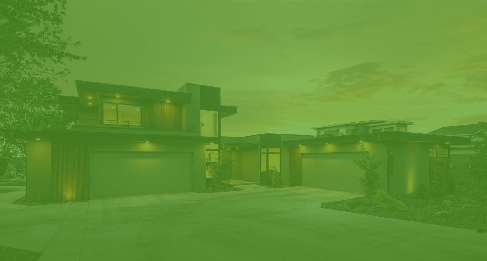 A green background of a modern house with two garages and a driveway.
