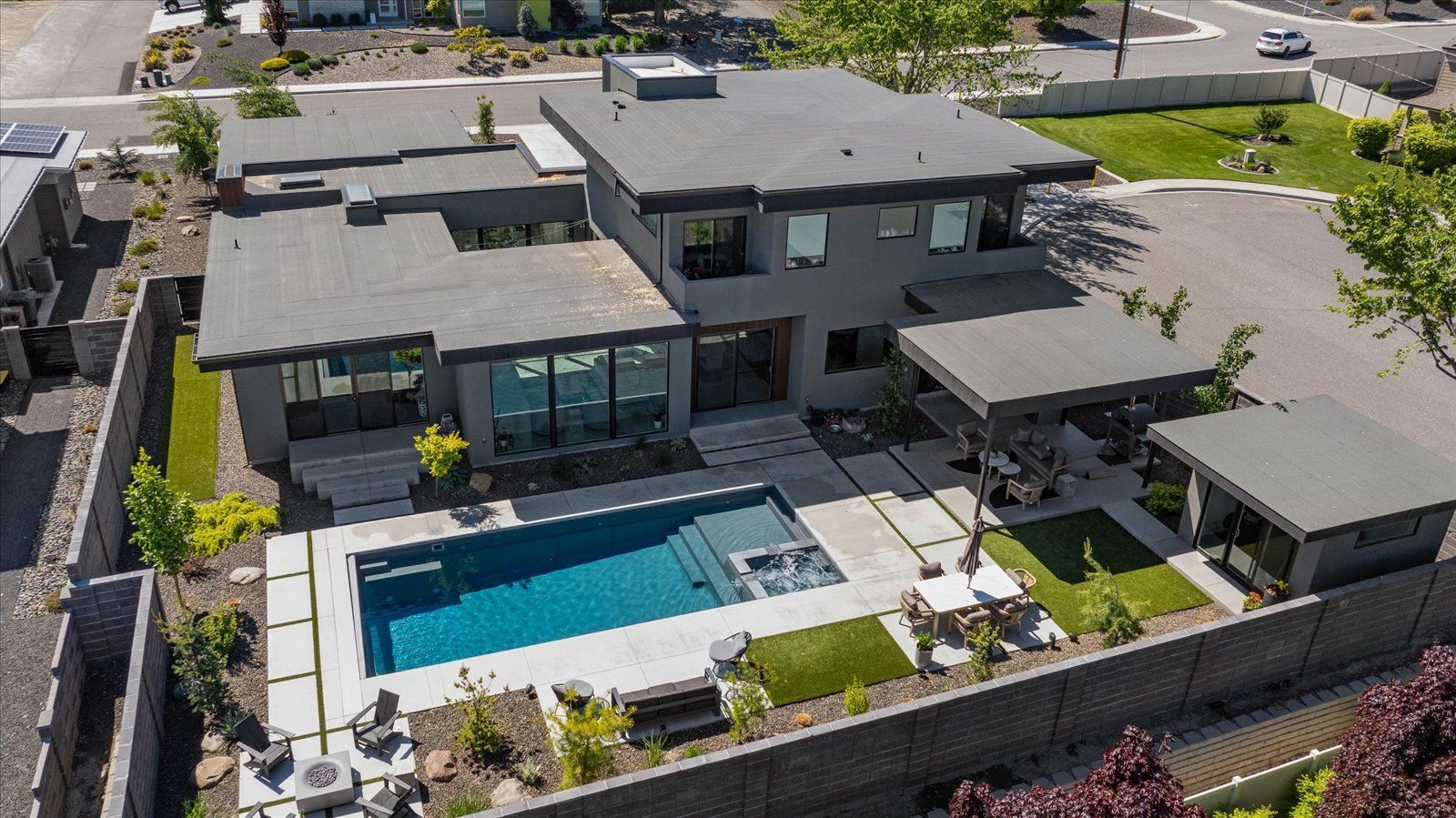 An aerial view of a house with a large swimming pool in the backyard.