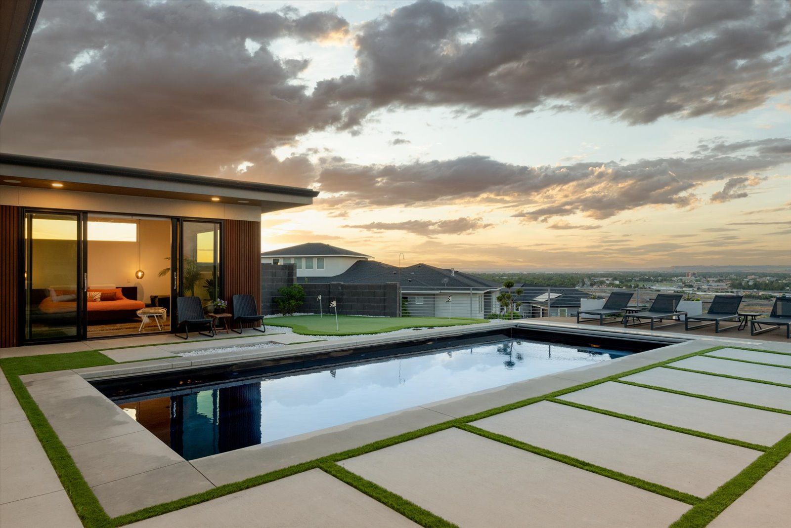 There is a large swimming pool in the backyard of a house.