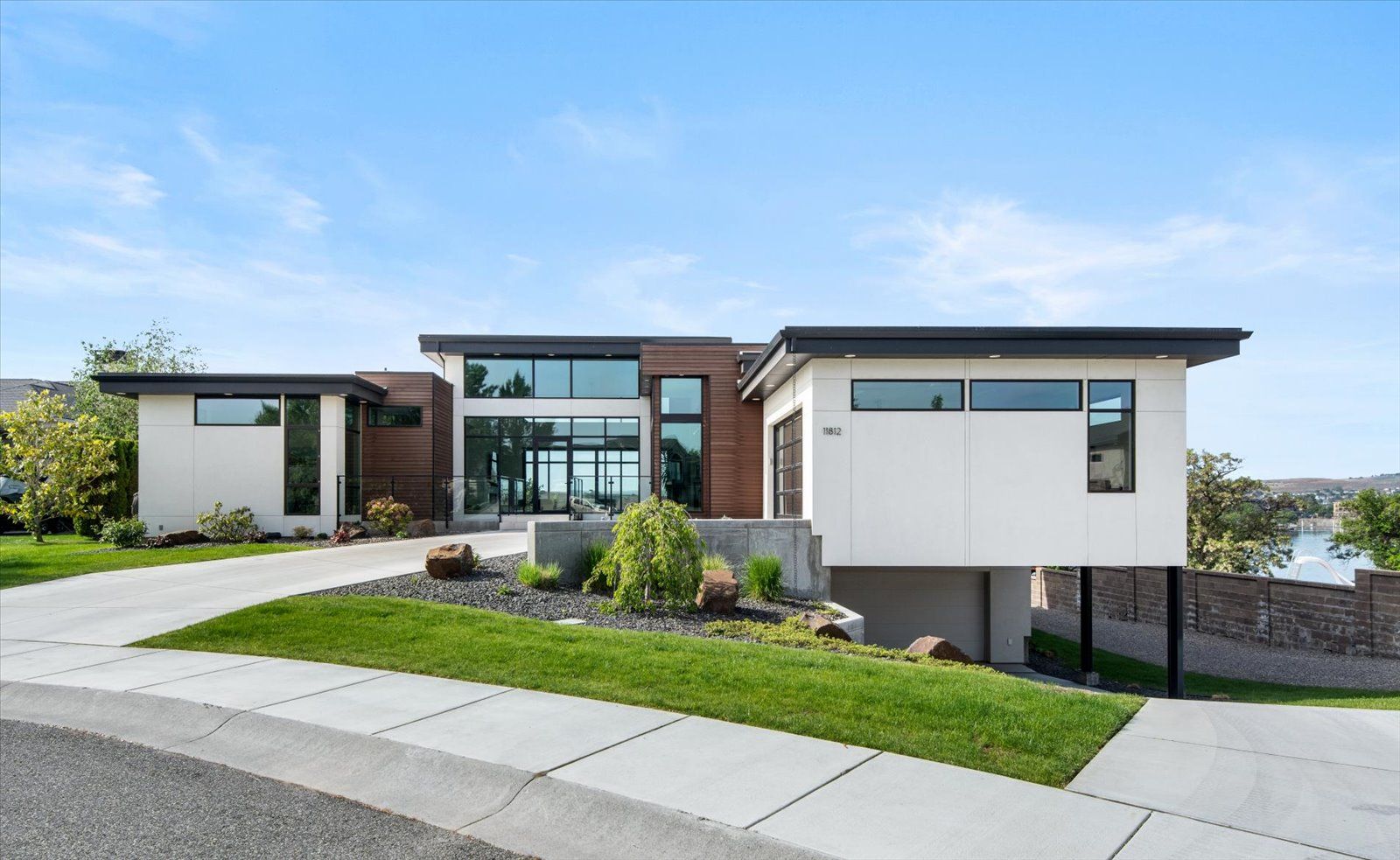 A modern house with a lot of windows is sitting on top of a hill.