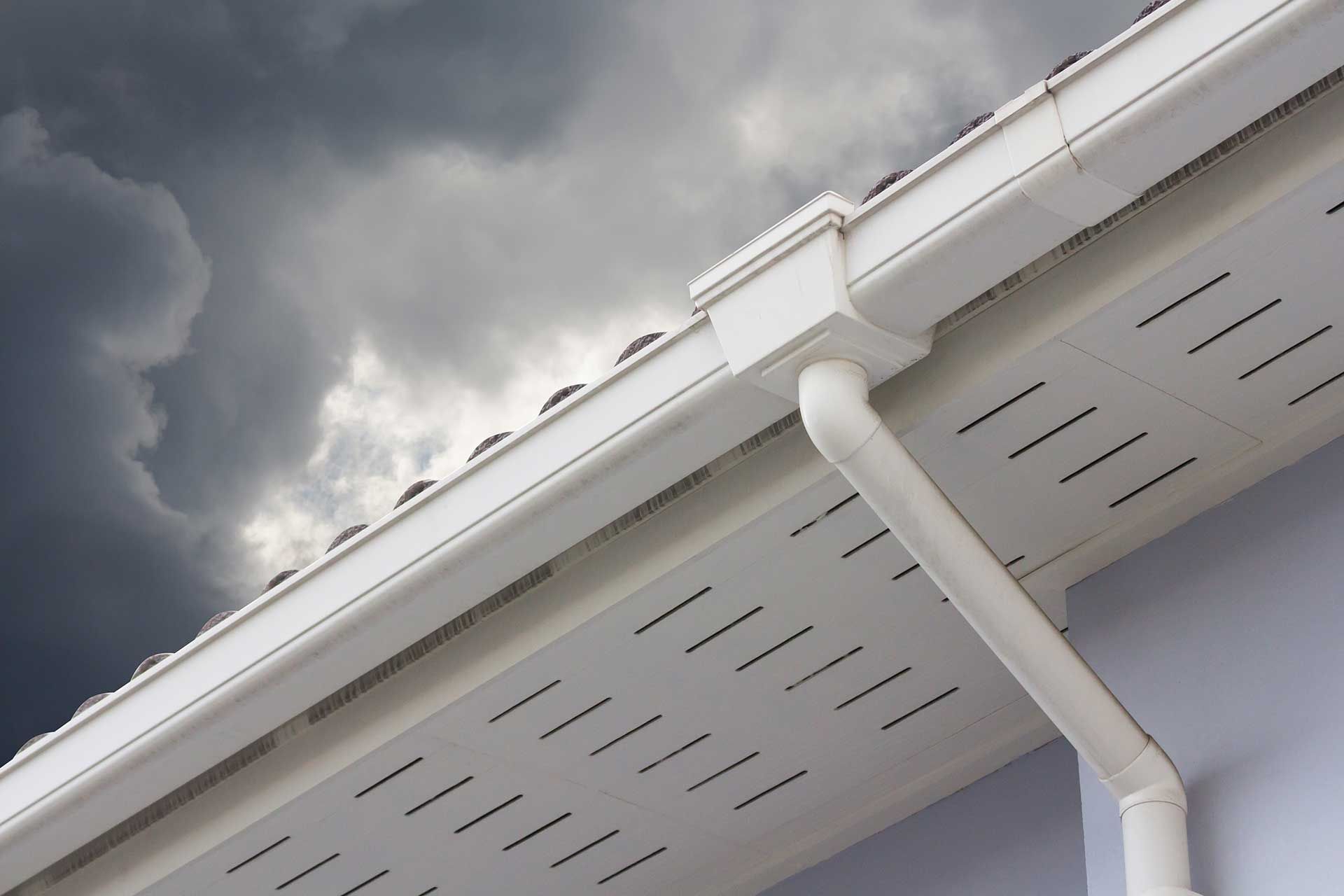 white plastic rain gutter and dark sky