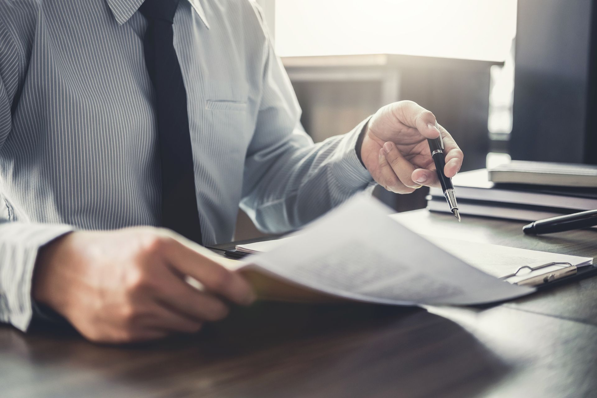 A Lawyer Is Sitting at A Table Talking to A Client — Monroe, MI — Apex Legal Group