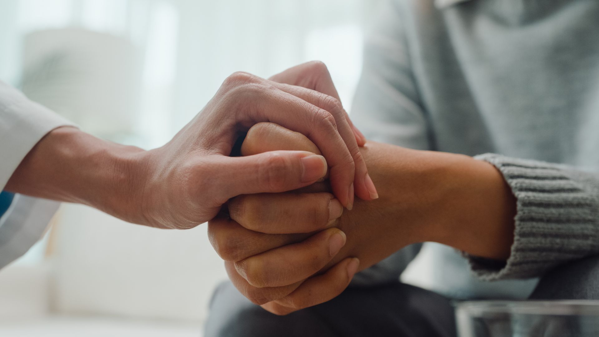 A close-up of a person holding another person's hand — Monroe, MI — Apex Legal Group