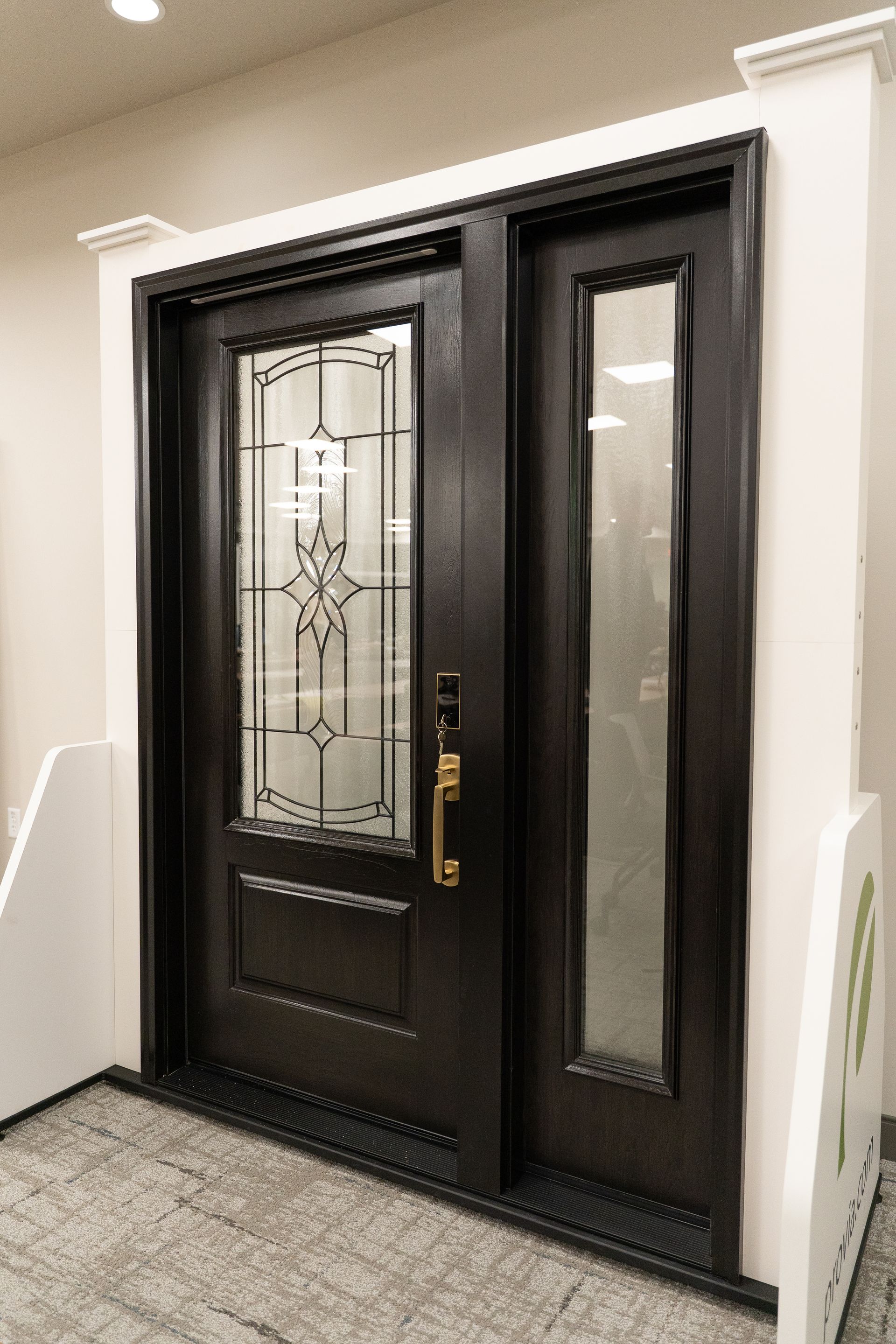 Black double front door with decorative glass panels in a hallway