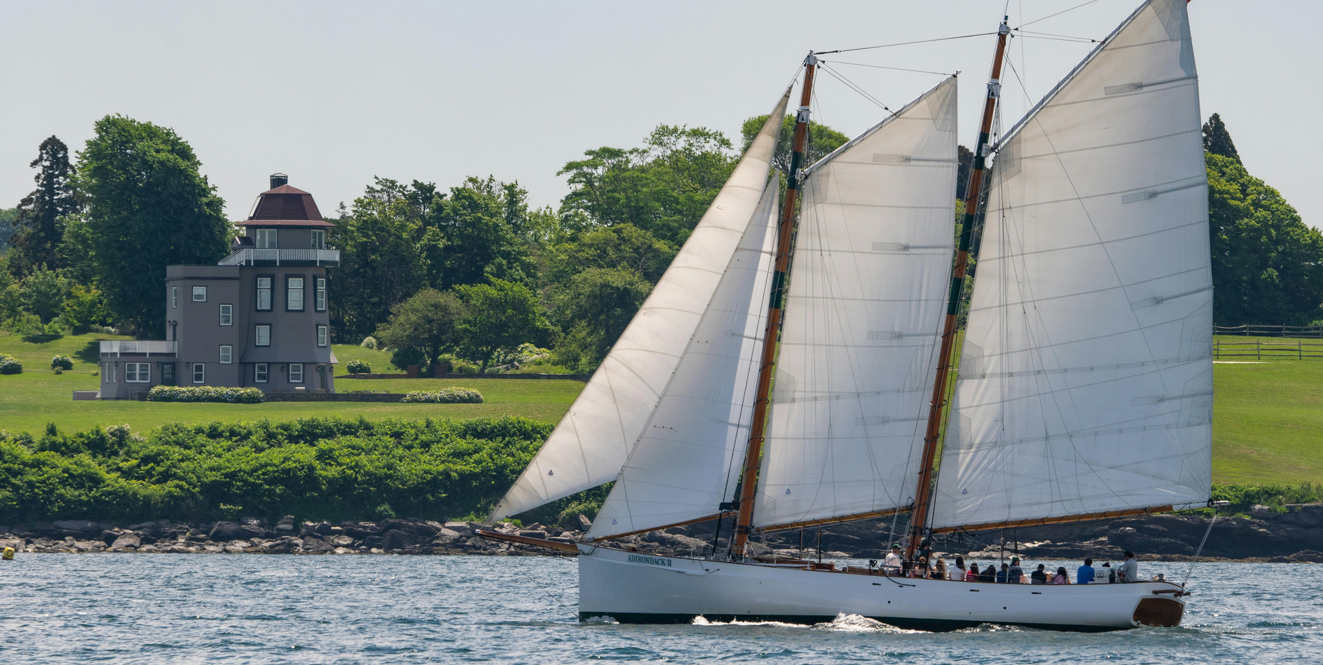 A sailboat in the water with people on it in Rhode Island