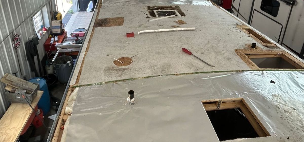 An RV Roof that is being torn apart for replacement with tools on the roof