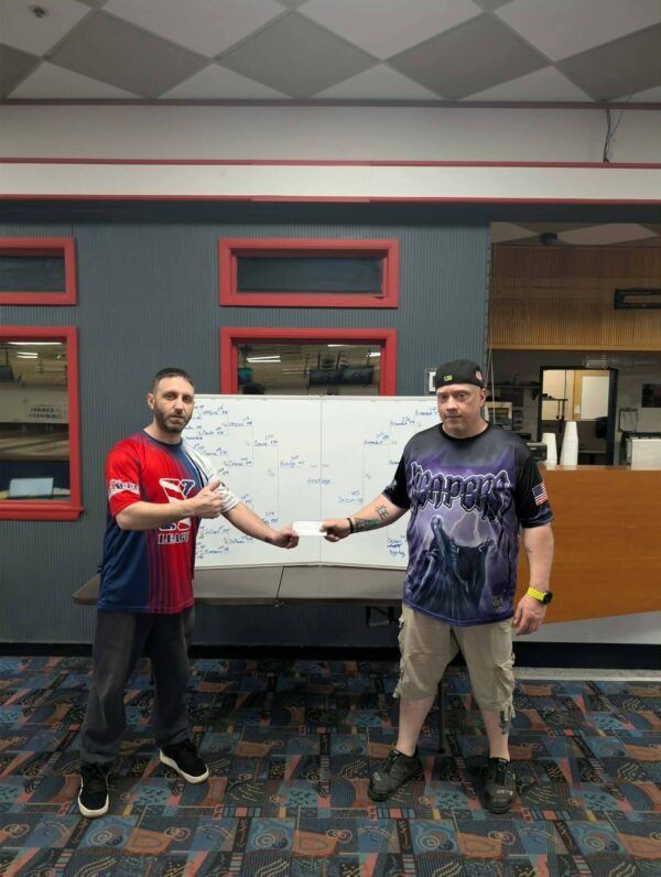 Two men standing in an office, shaking hands in front of a whiteboard