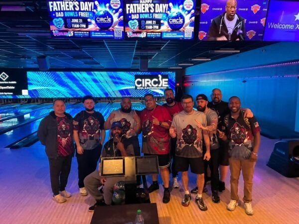 Group posing in a blue-lit arcade with bowling lanes and Circle branding in the background.