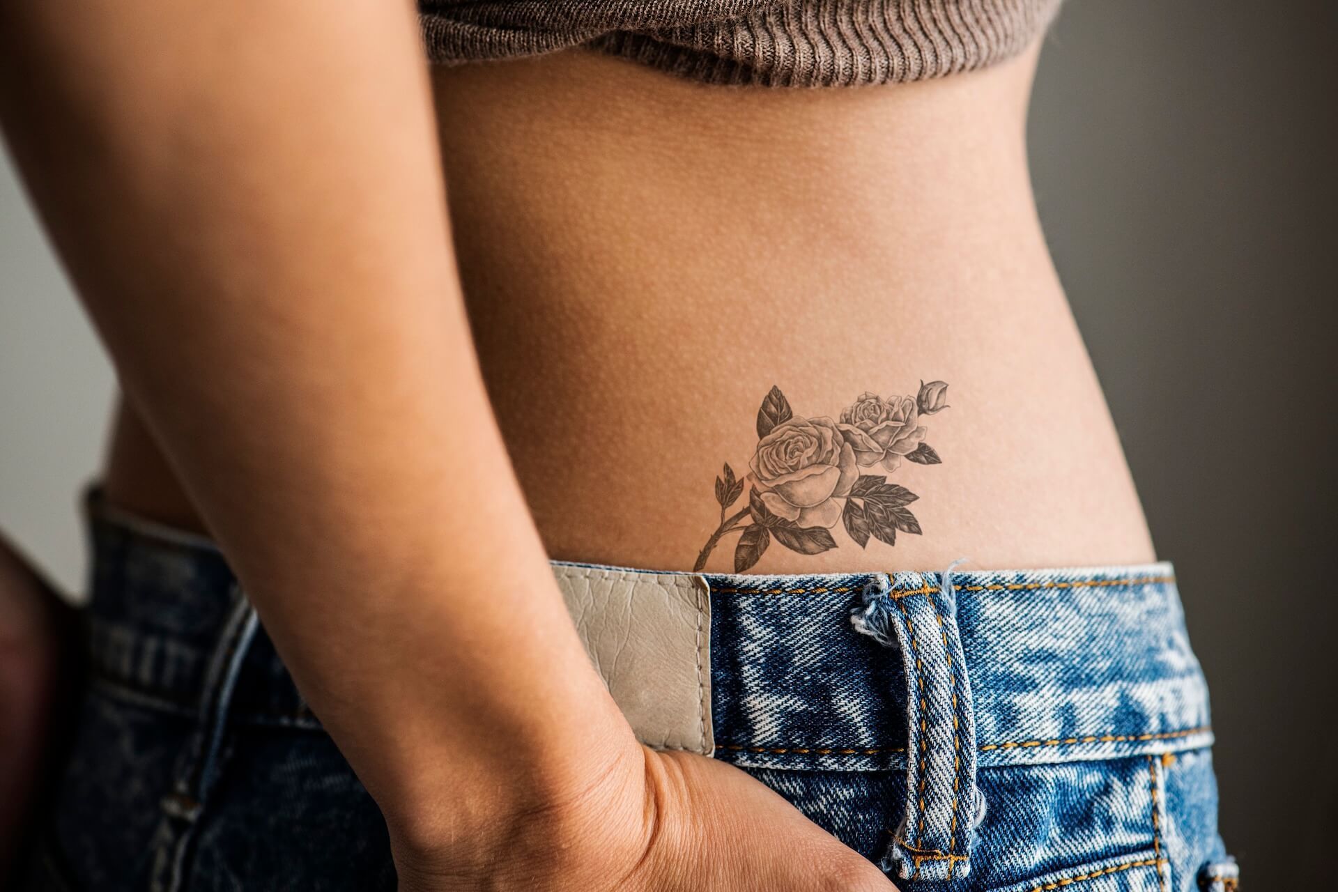 Close-up of a woman with a floral tattoo in an intimate area