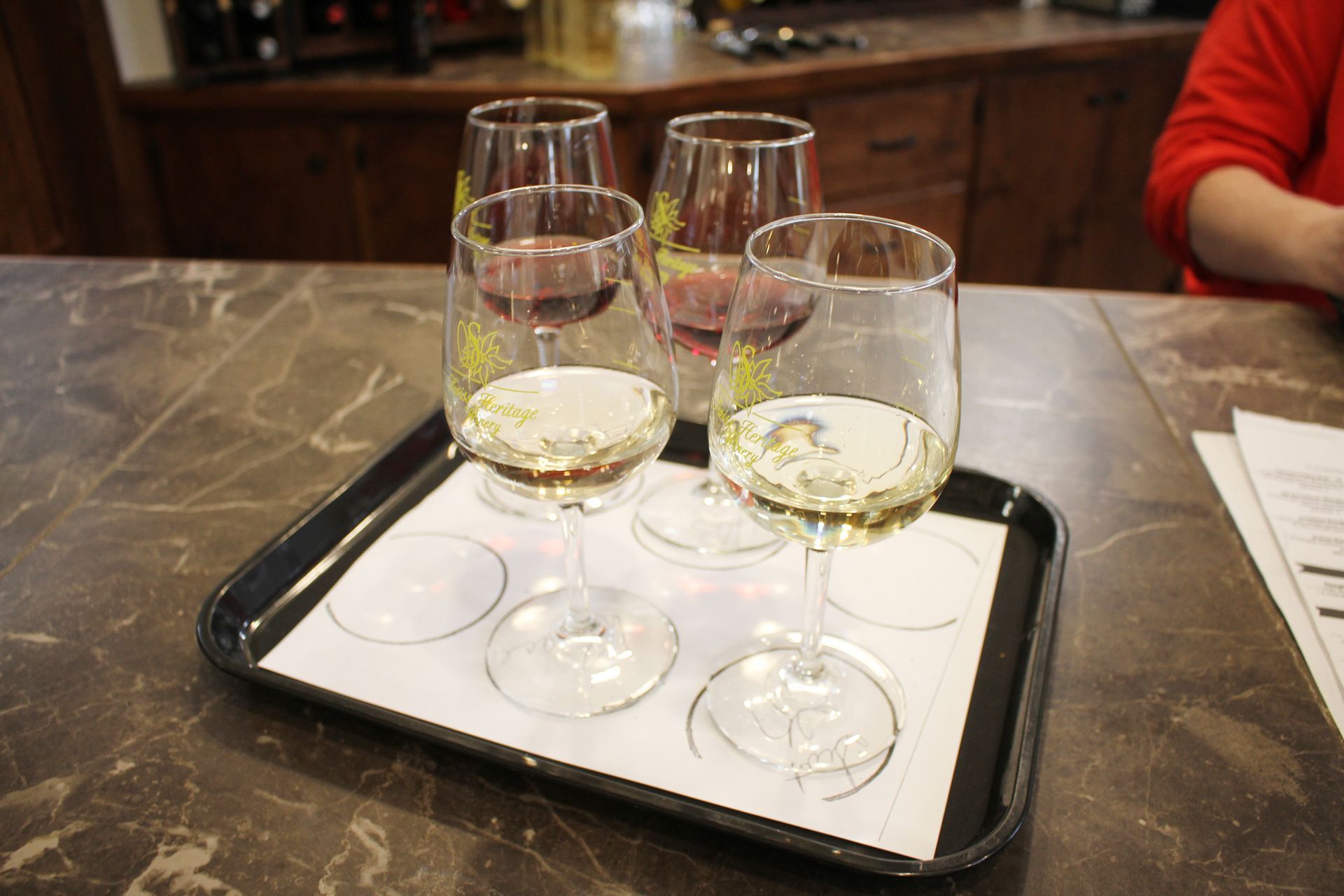 Wine glasses on a tray with white and red wine at a winery.