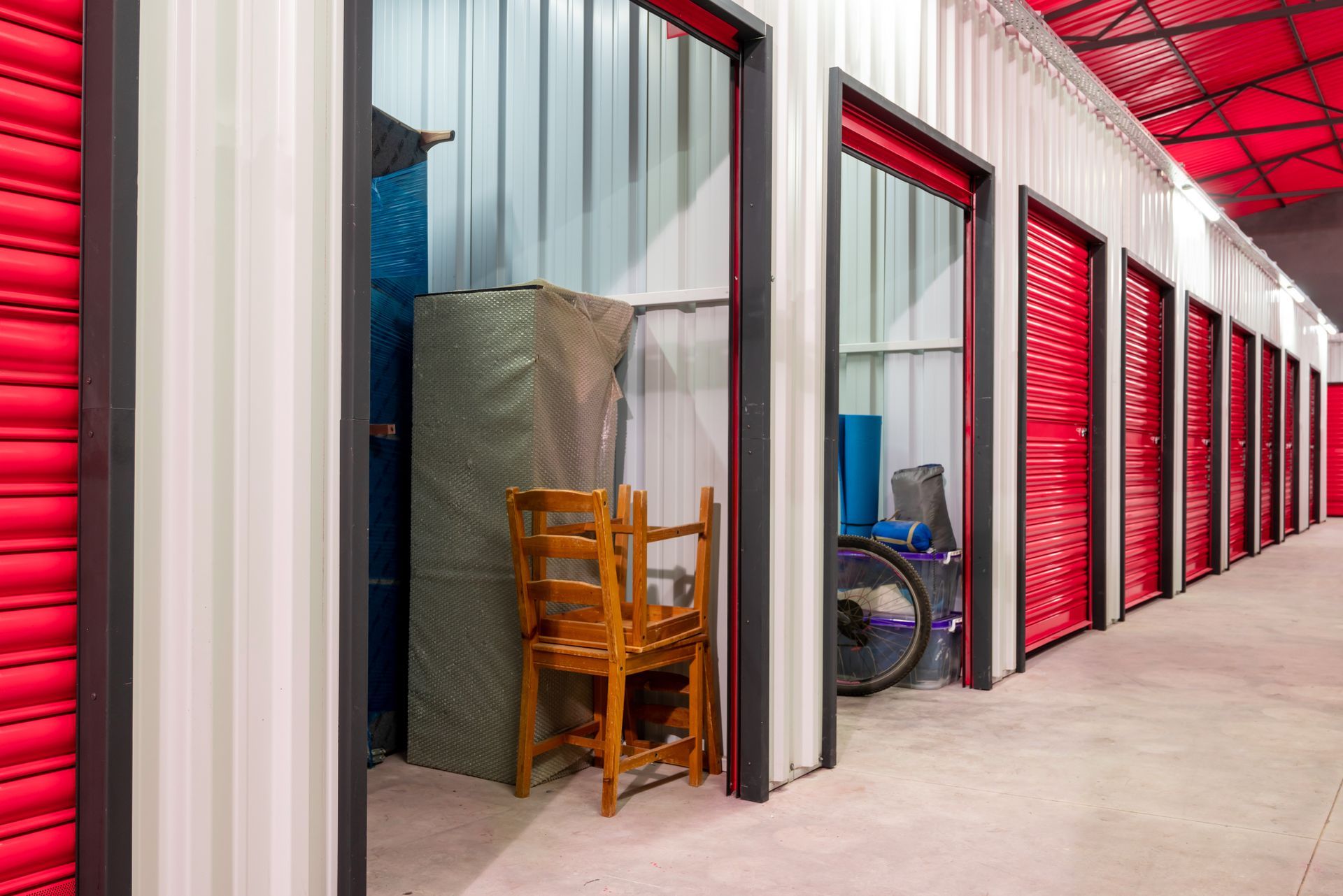 Corridor lined with red doors of indoor self-storage units
