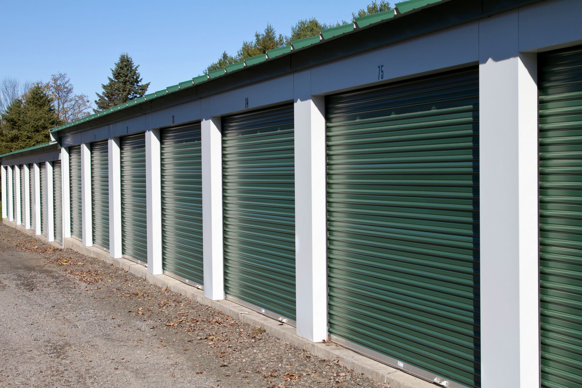A hallway with green shutters on the doors of a storage unit.