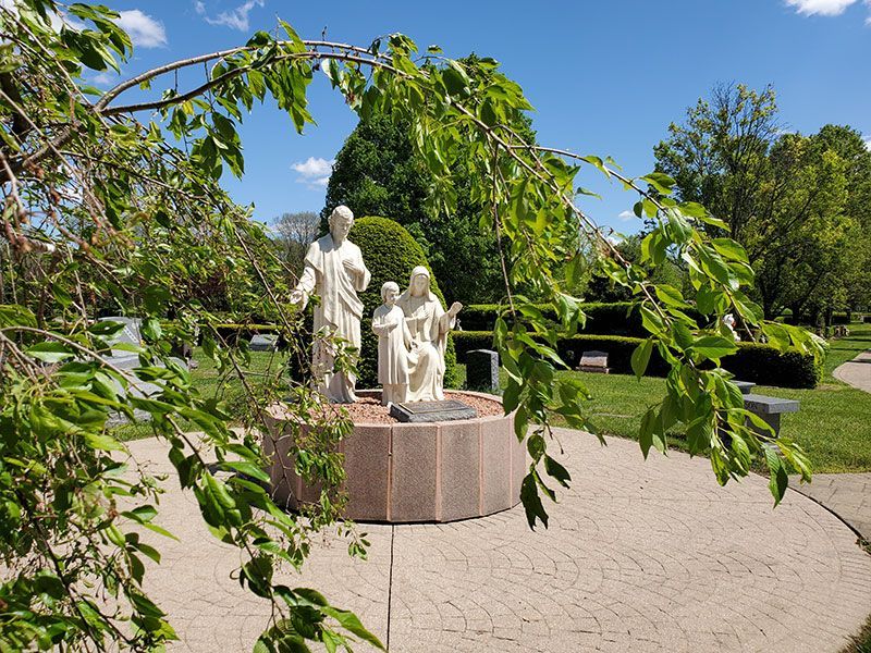 Calvary Cemetery Statue through trees