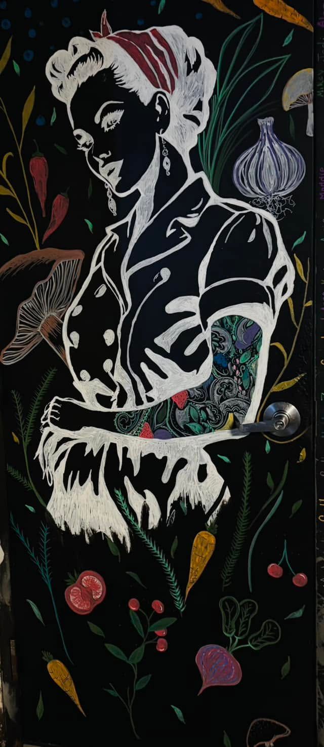 Stylized black-and-white portrait with colorful floral and leaf accents on a dark background