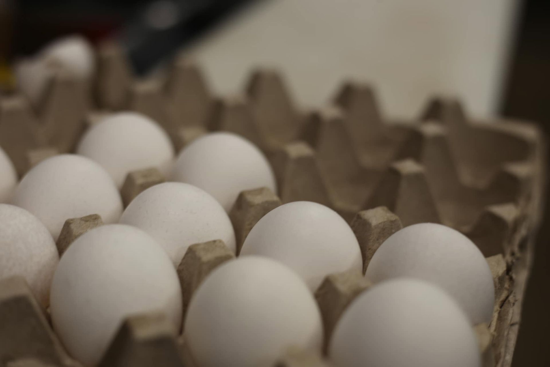 Carton of white eggs in a cardboard tray, close-up
