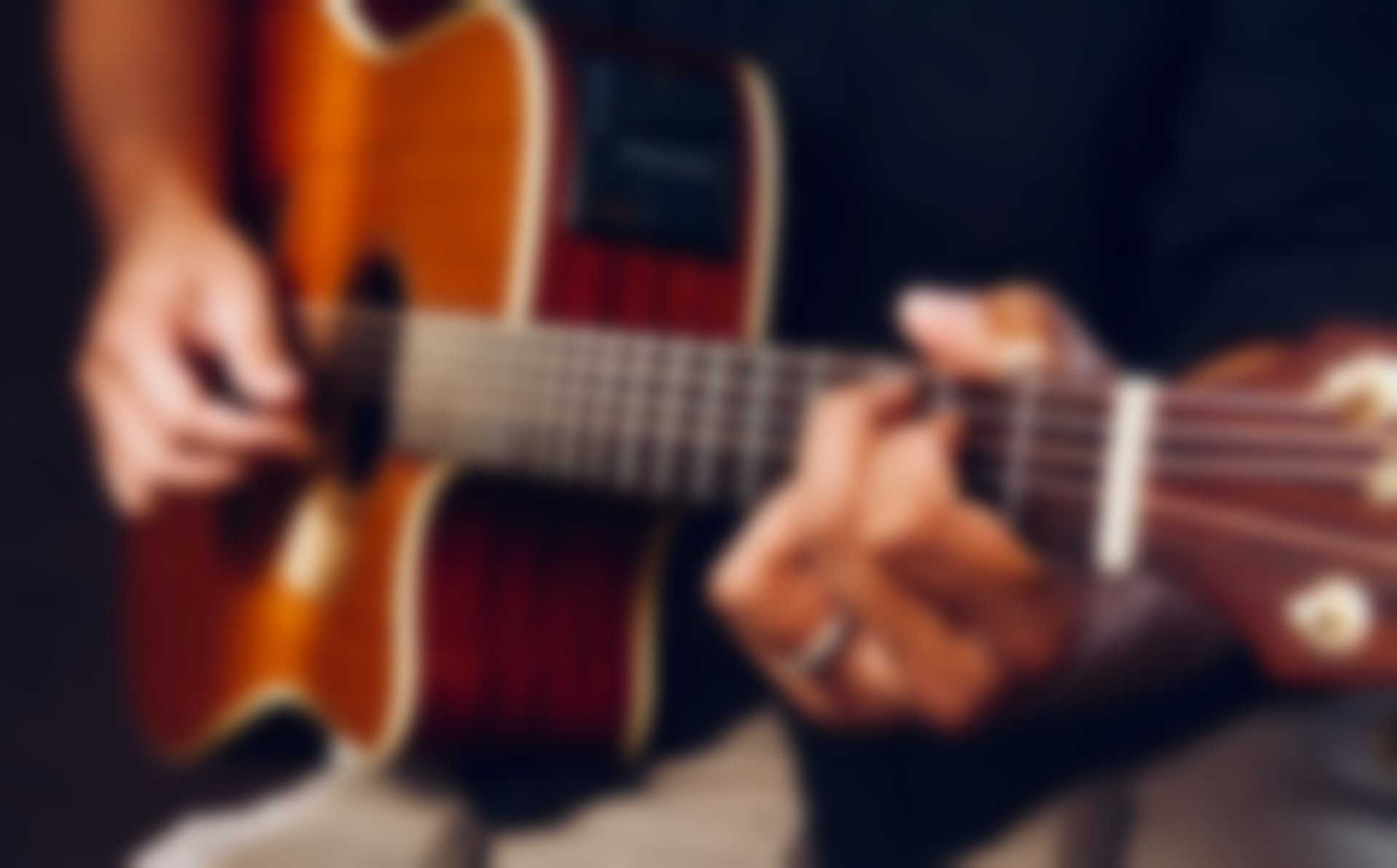 Person playing acoustic guitar, hands close up, strumming strings.
