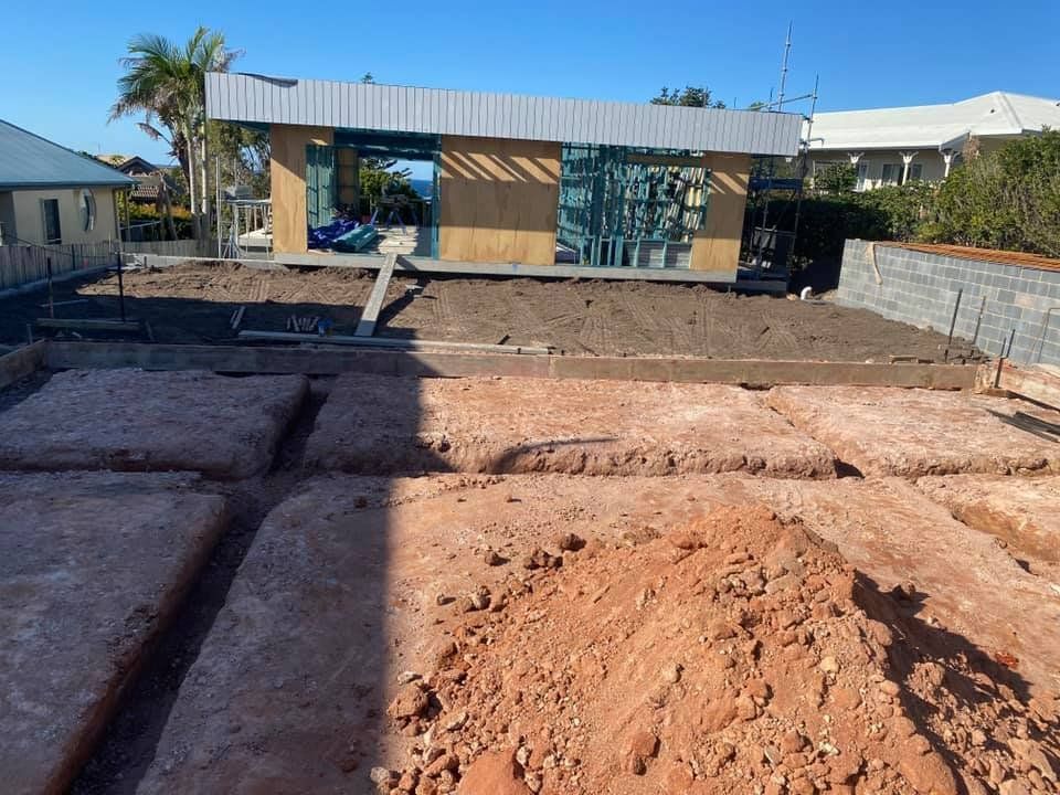 A Bulldozer is Loading Sand Into a Dumpster  — Jaya Rose Earthworks and Landscape Contractors In Gulmarrad, NSW
