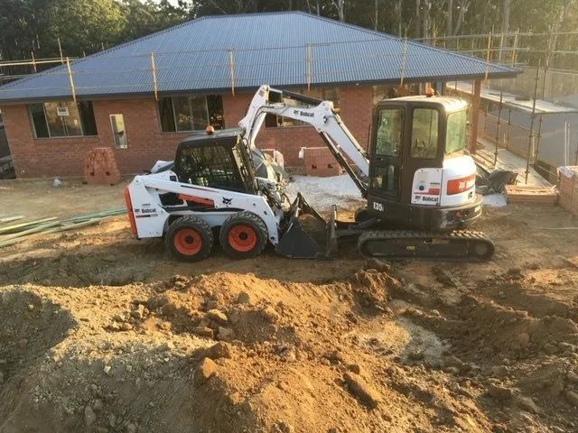 A Bulldozer is Digging a Hole in the Dirt —Jaya Rose Earthworks and Landscape Contractors In Wooli, NSW