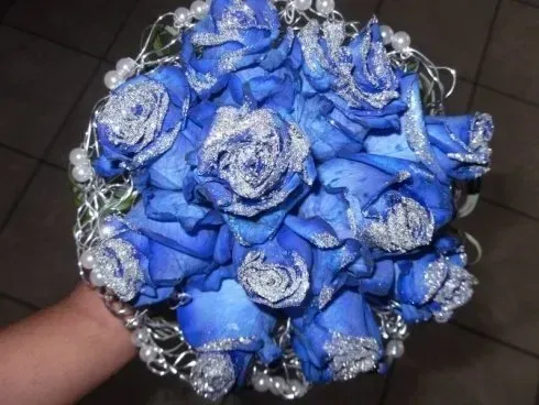 Bouquet di fiori artificiali blu e argento con dettagli in strass, tenuto in mano