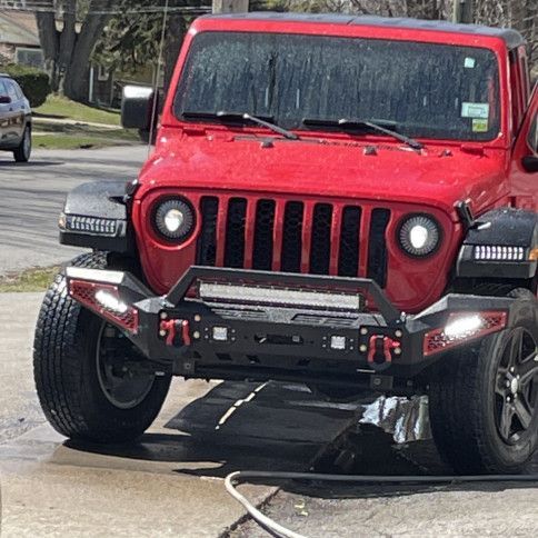 A red jeep is parked on the side of the road