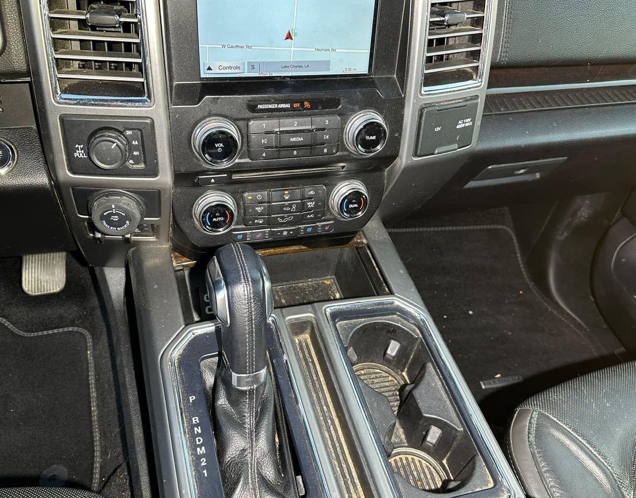 The dashboard of a car with a gps and a cup holder