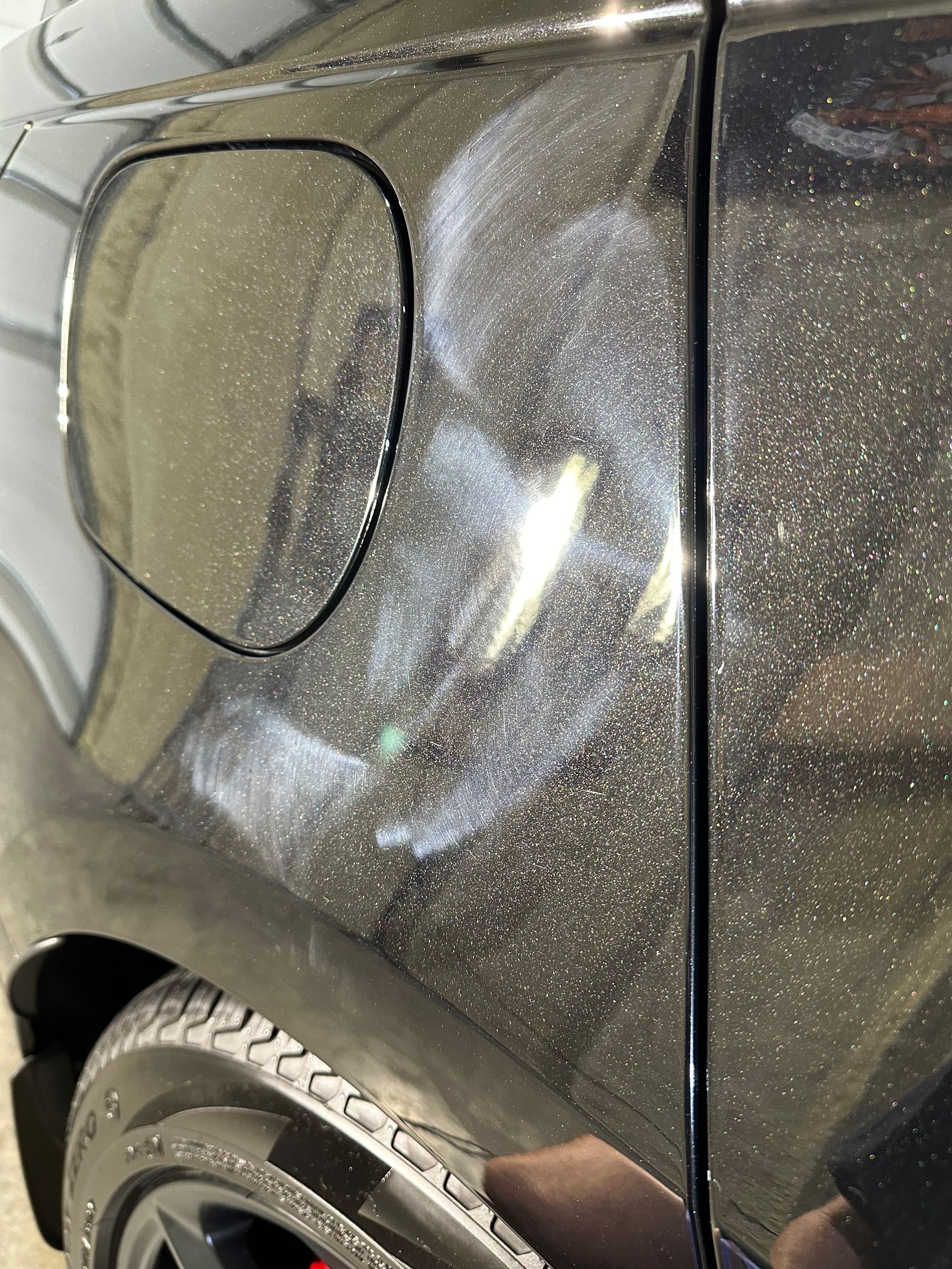 A close up of a black car with a fuel tank open.