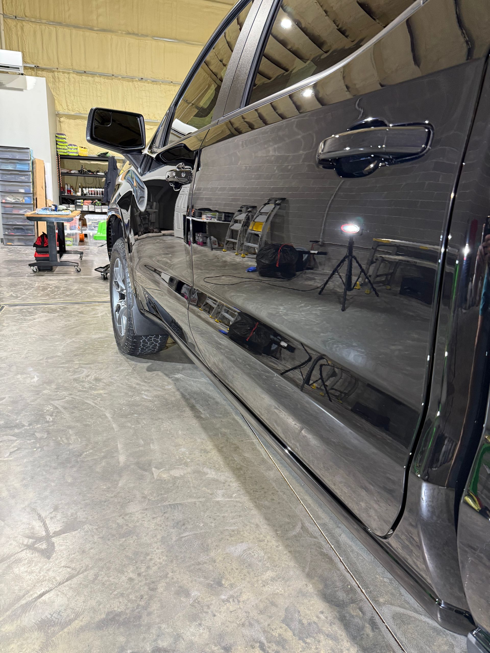 A black truck is parked in a garage.