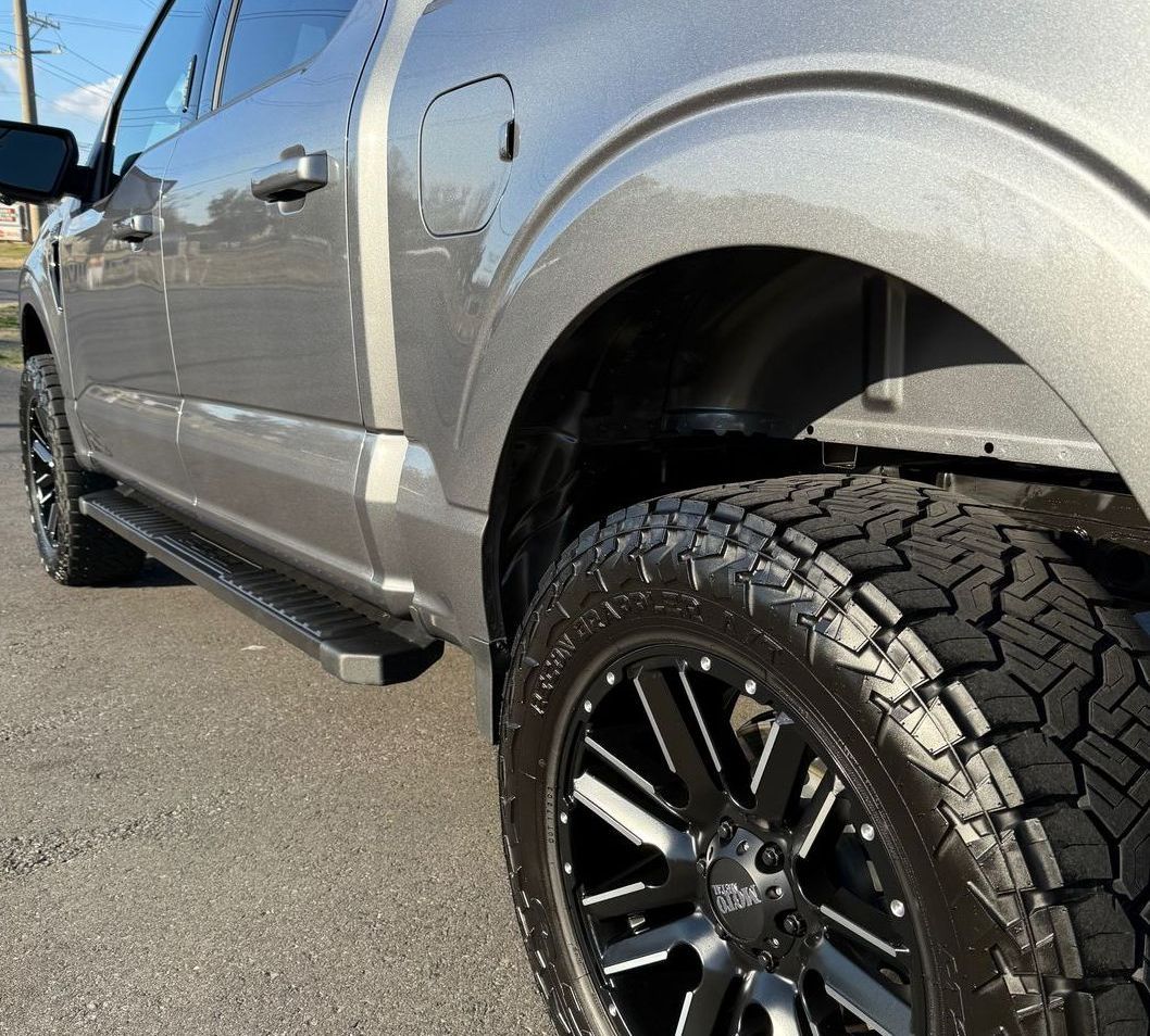 A silver truck is parked on the side of the road