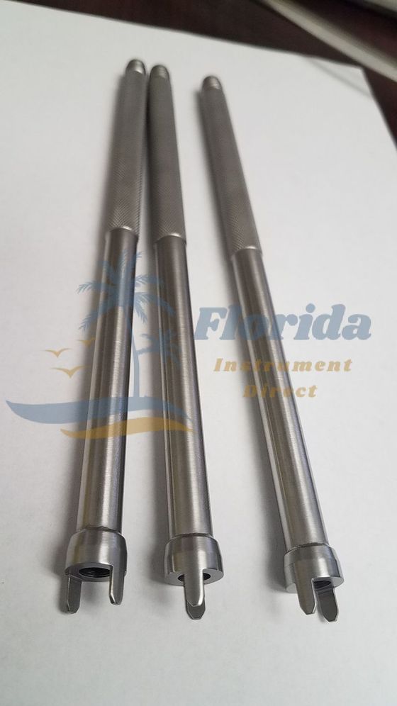 Three metal cylindrical tools with forked ends arranged upright on a white surface.