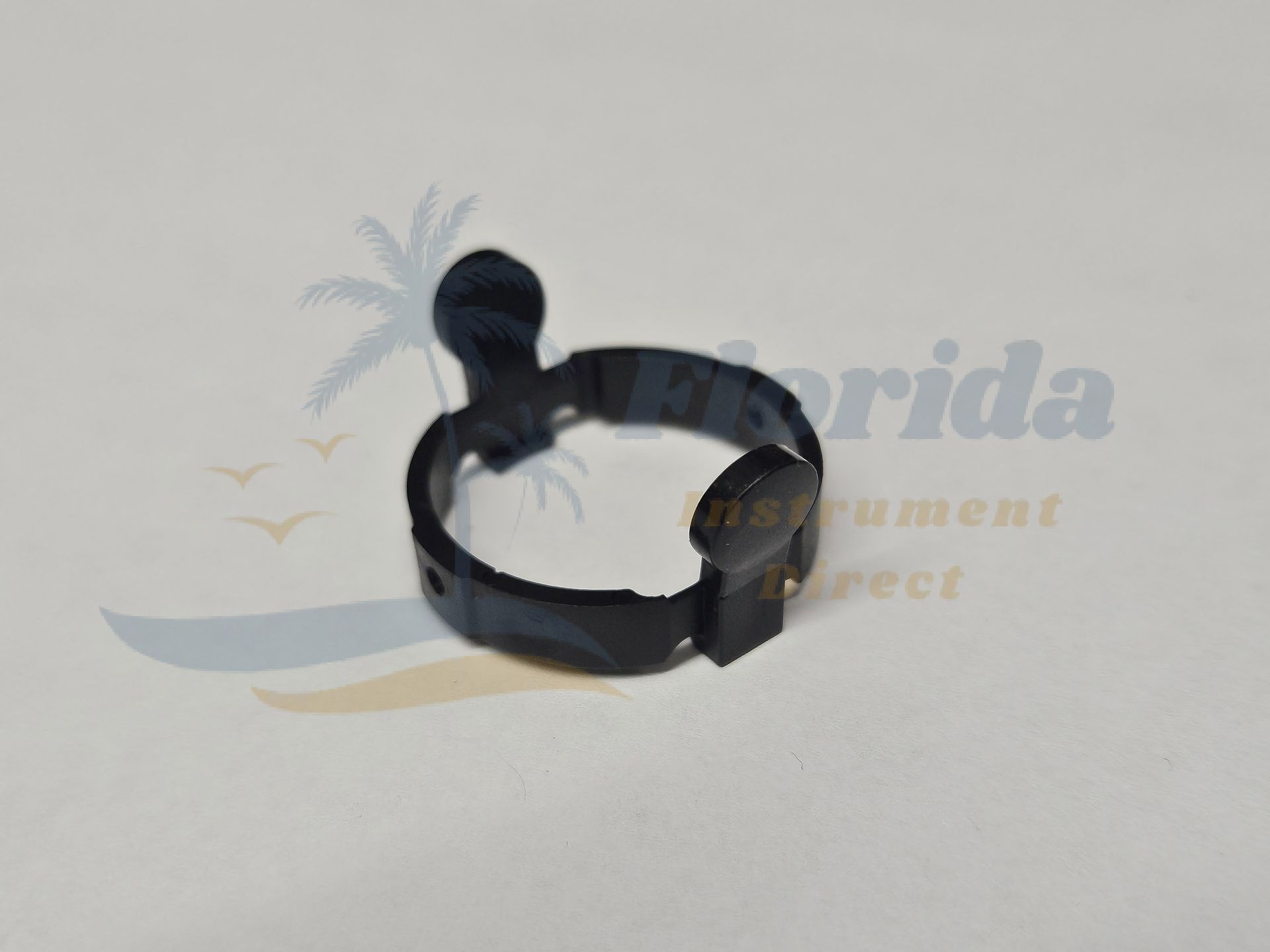 Black plastic hose clamp with a tightening screw on a light background
OLympus Lock Ring Replacement Part