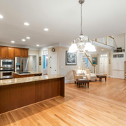 Spacious kitchen and dining area with wood floors, granite island, and chandelier lighting