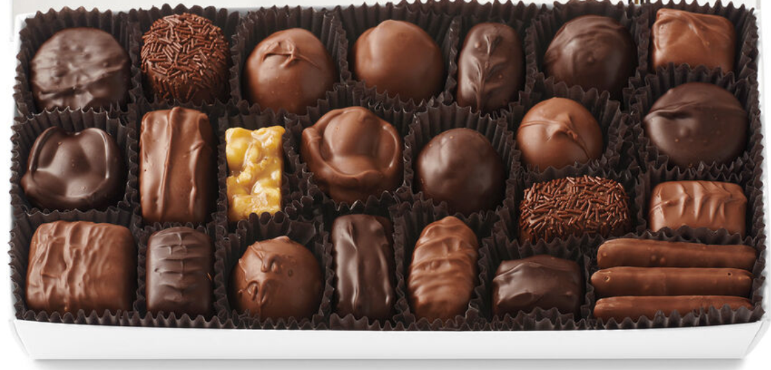 A box of assorted chocolates in various shapes, sizes, and textures.