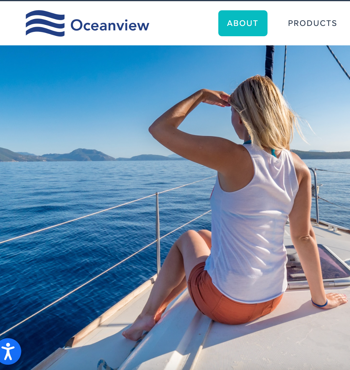 Woman on a sailboat looking out at the ocean. Blue sky and water.