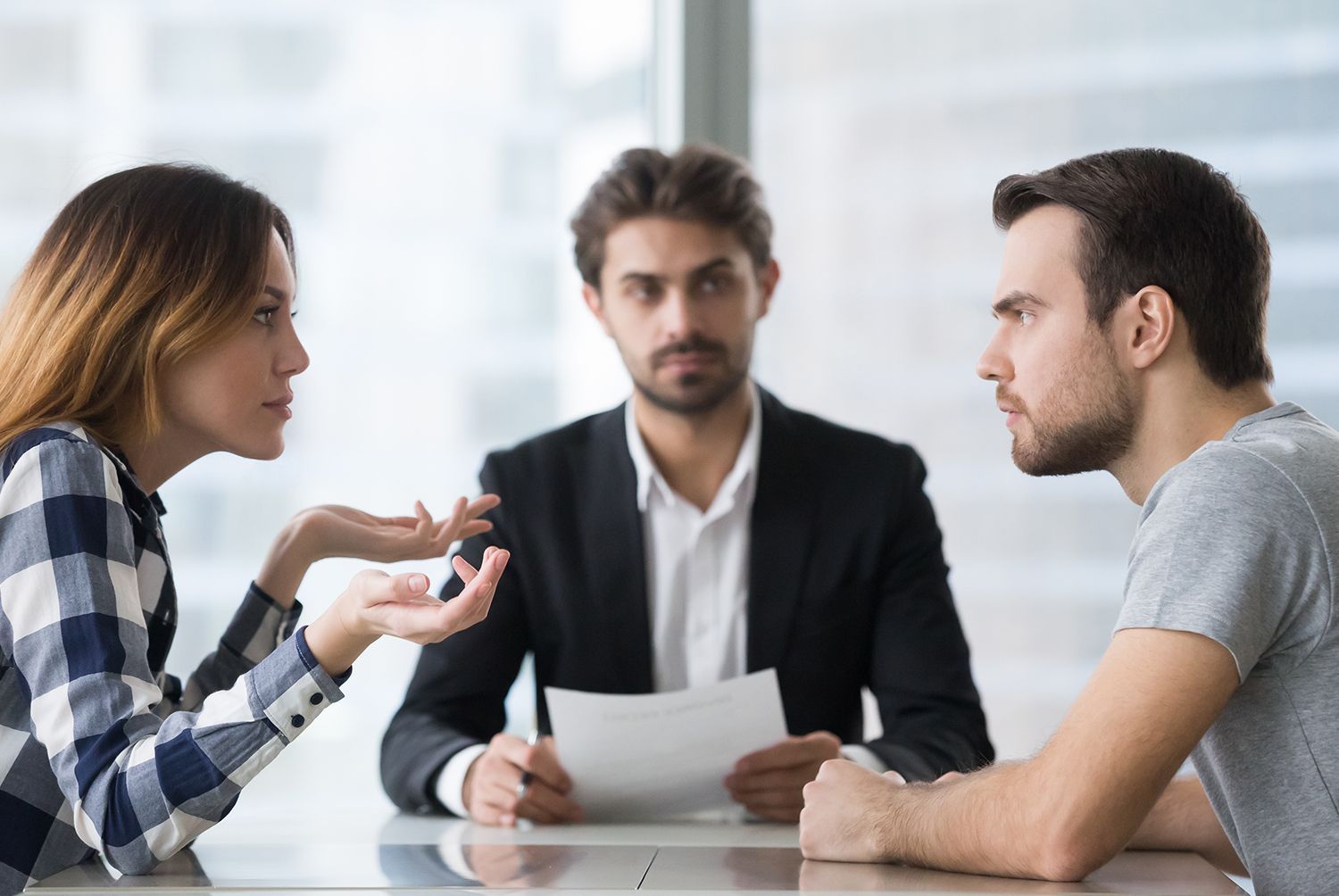 A couple is arguing in front of a lawyer. A couple is arguing in front of a lawyer.