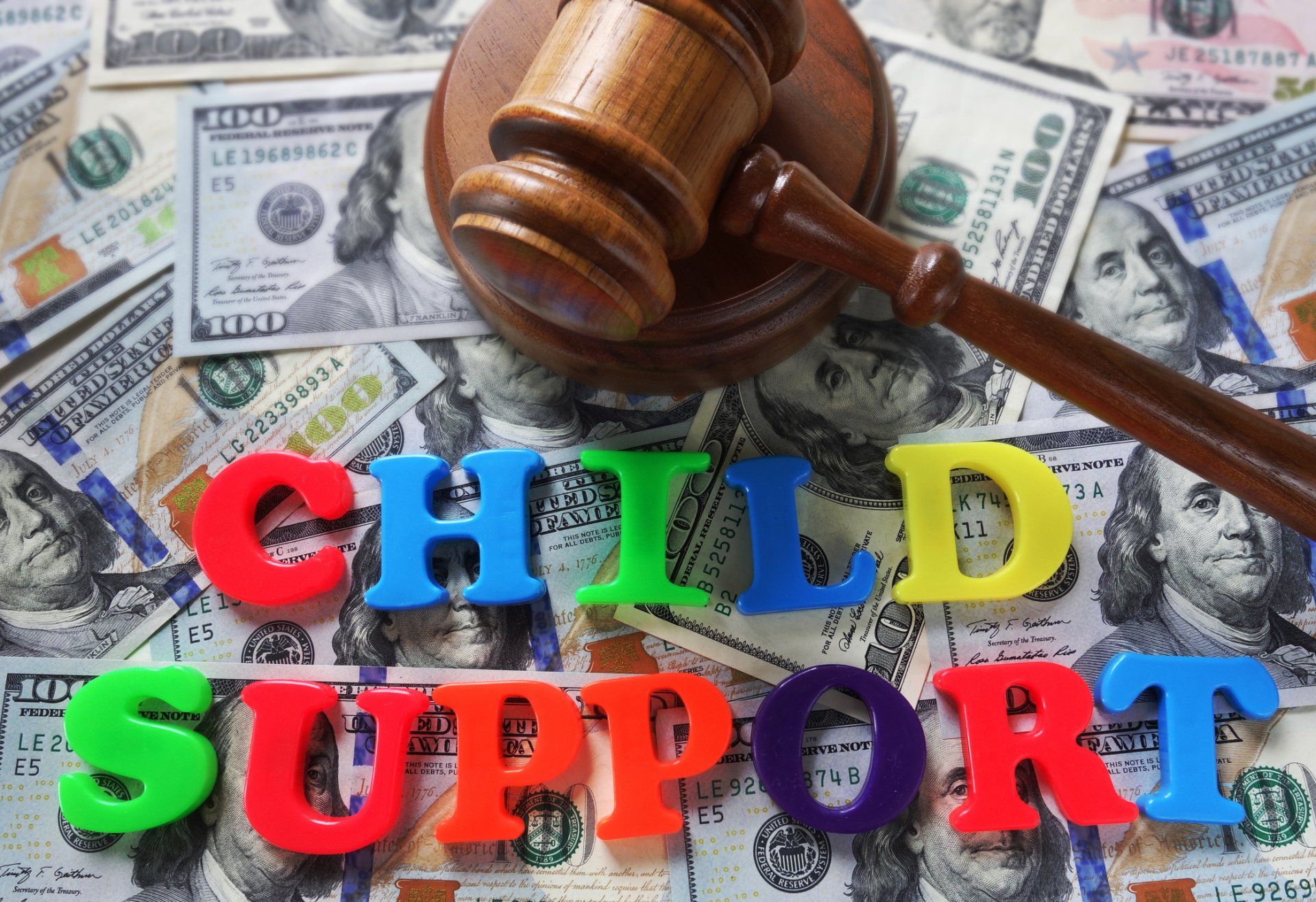 Child support — Elkhart Lake, WI — Pro Se Divorce & Mediation Services S.C. Wooden gavel on top of money and the word “CHILD SUPPORT” in colorful letters.