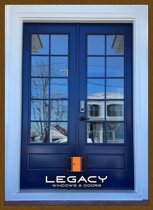 Blue double doors with glass panels reflecting a building and tree. White trim.