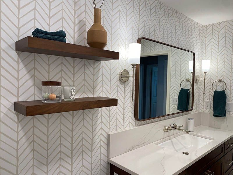 A bathroom with a sink , mirror and shelves.
