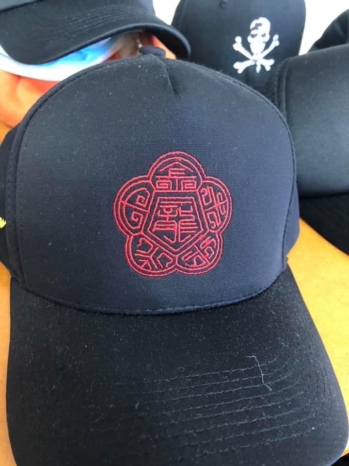 A Black Baseball Cap With A Red Emblem On It — Carnival Clothing In Miami, QLD