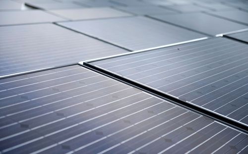 Rows of blue-gray solar panels reflecting light in a clean, geometric pattern