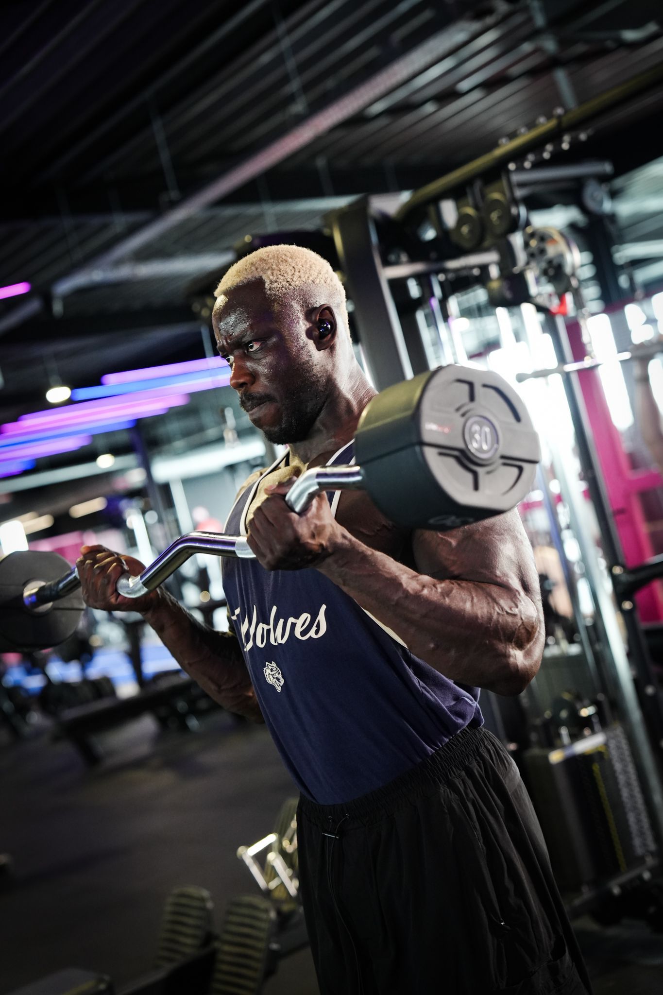 Een grote lege sportschool met veel fitnessapparatuur.