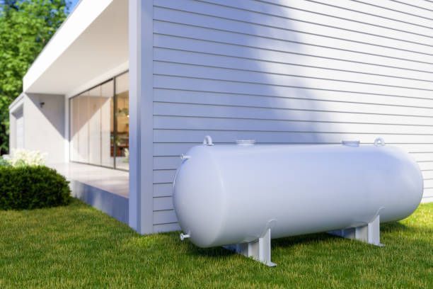 White propane tank on grass next to a white house with sliding glass doors.