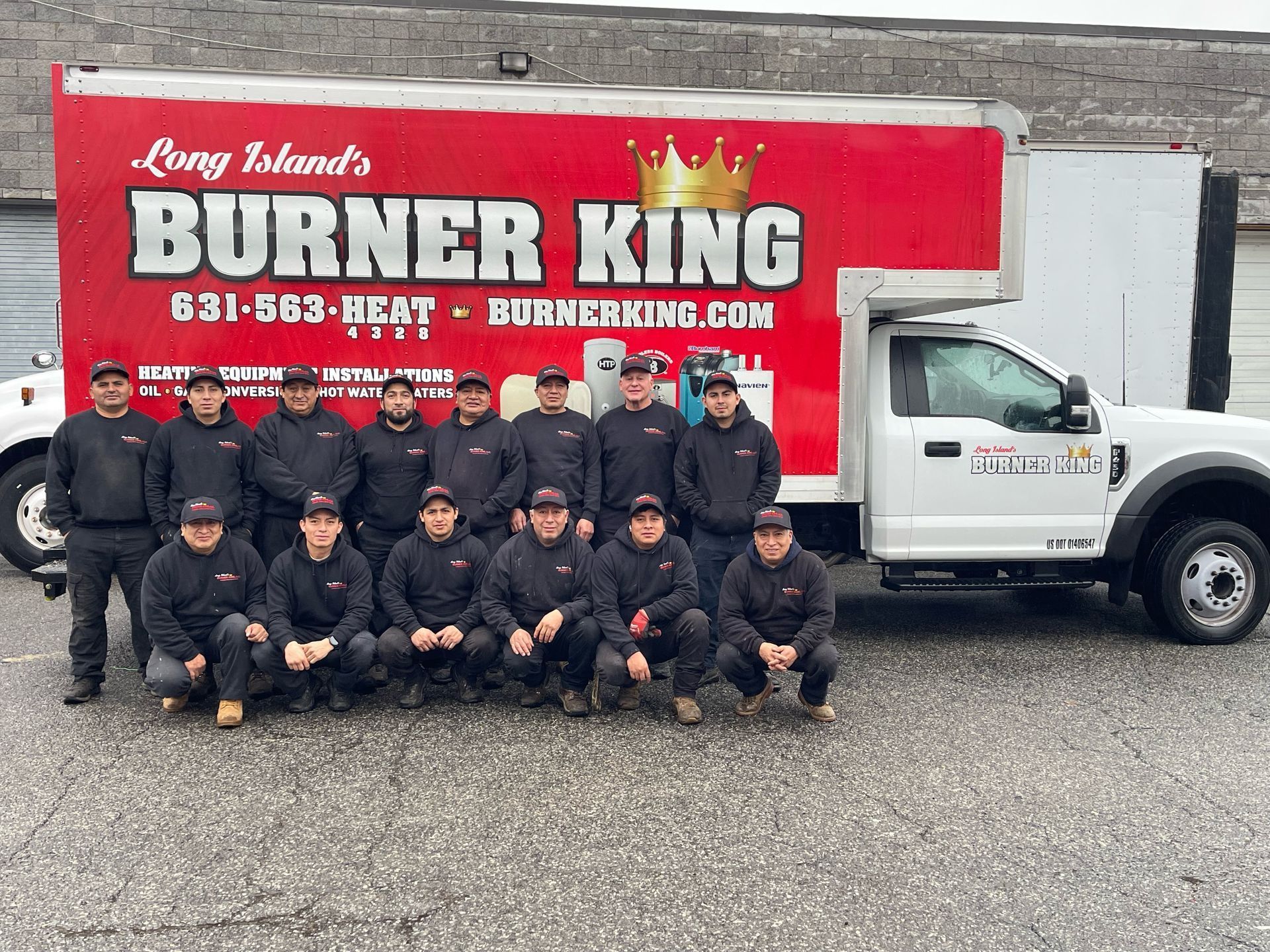 A team of men in black uniforms pose in front of a white truck with