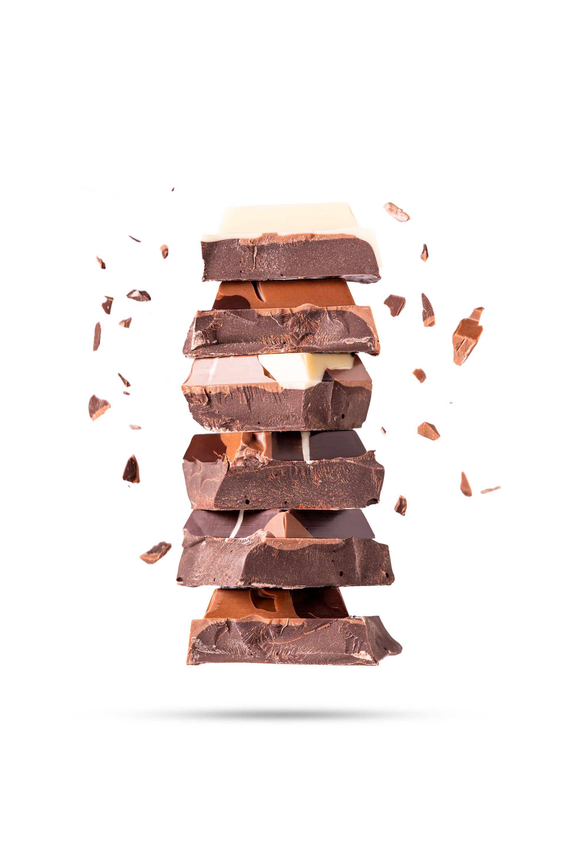 Stapel met verschillende stukken chocolade, waarvan sommige uit elkaar vallen en kruimels bevatten.