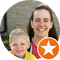 A woman and a child are smiling in a circle with an orange star.