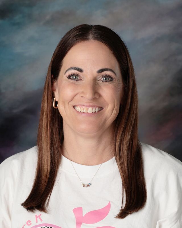 A woman wearing glasses and a red and white shirt is posing for a picture.