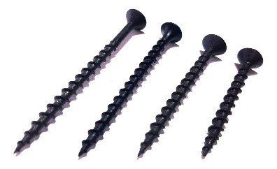 Cuatro tornillos negros están alineados en fila sobre un fondo blanco.