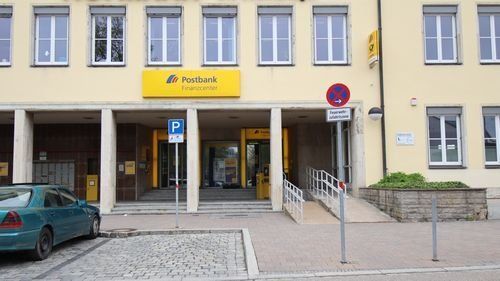 Bahnhofsplatz 8, mehrstöckiges Geböude, Eingang Treppe und Rampe, davor Parkplätze