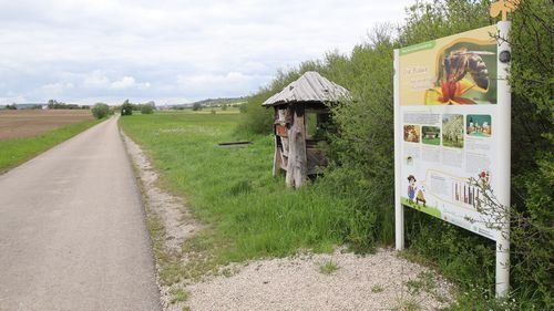 Asphaltierter Weg durch Wiesen, am Rand Insektenhotel und Schautafel. Asphaltierter Weg durch Wiesen, am Rand Insektenhotel und Schautafel.