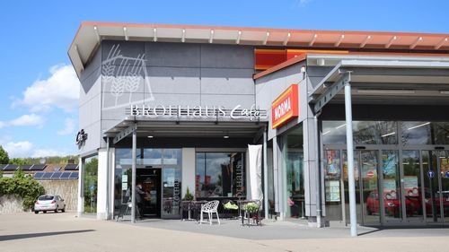 Brothaus Cafe neben Norma. Modernes Gebäude mit großen Glasflächen.