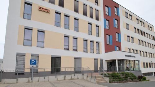 Draisstraße 2c, Modernes mehrstöckiges Gebäude, mit Treppe und langer Rampe, davor Parkplatz